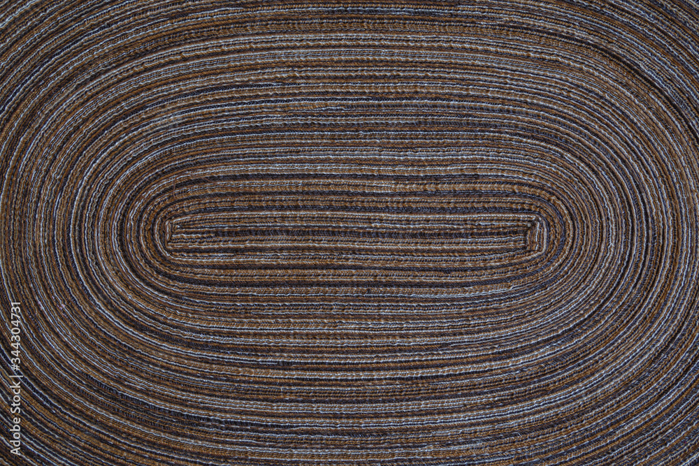 Close-up of a brown and light gray tablet mat or placemat, viewed from above. Full frame textured background. Copy space. Close-up of a brown and light gray tablet mat or placemat, viewed from above. Full frame textured background. Copy space.