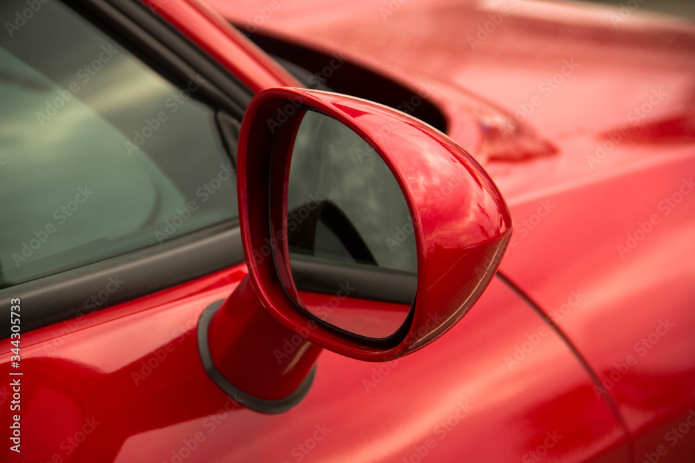 Rearview mirror. Part of a red car close up