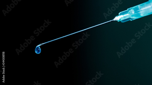 Syringe with vaccine medicine isolated on dark background, closeup