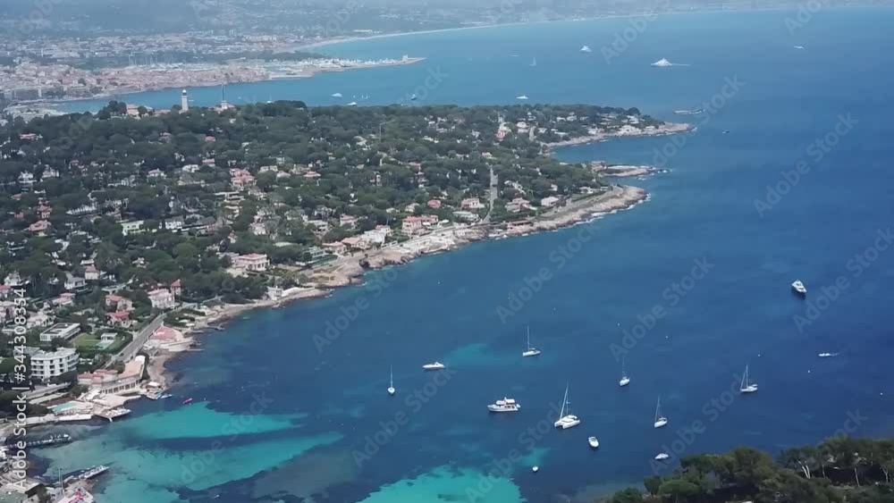 Copter Top view of waterfront with beach sand with sail boats and yachts on the warm sunny day, rooftops of buildings and houses on the seashore with deep water bay Copter Top view of waterfront with beach sand with sail boats and yachts on the warm sunny day, rooftops of buildings and houses on the seashore with deep water bay