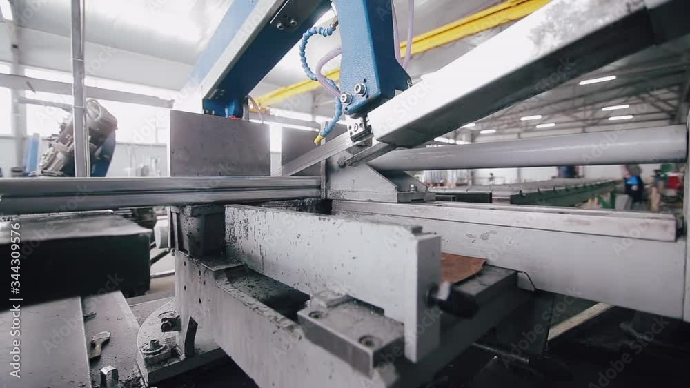 Band saw saws a stack of metal profiles for the production of plastic windows and doors. Cutting metal profiles for plastic windows. Band saw saws a stack of metal profiles for the production of plastic windows and doors. Cutting metal profiles for plastic windows.