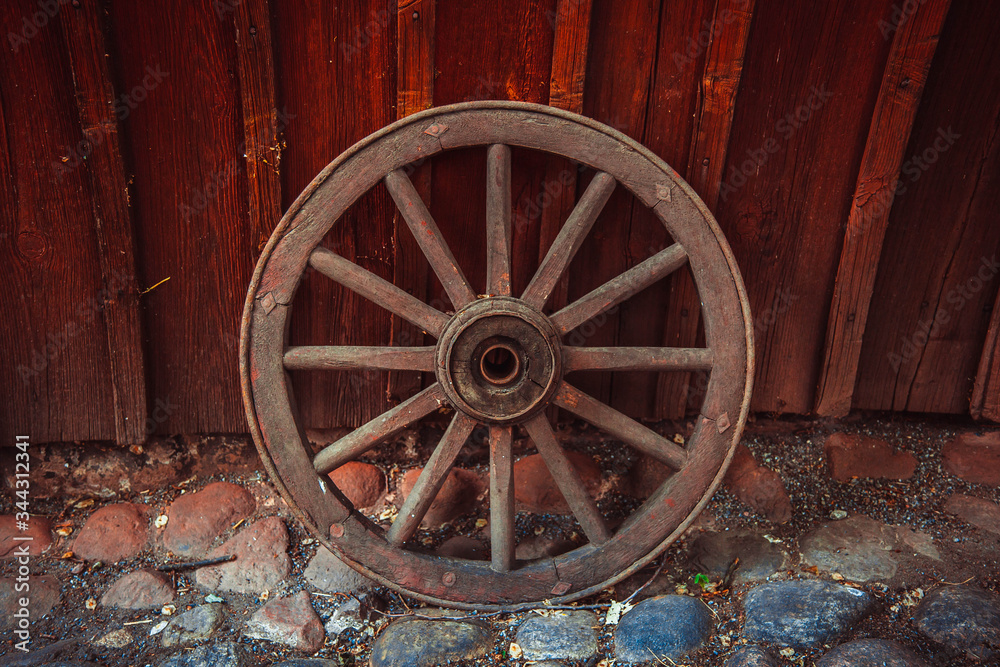 This photo shows a closeup of old wooden wheel in the village.