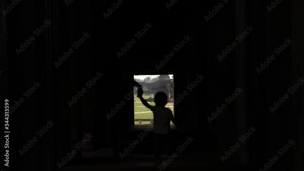 Madre e hijo entrando por una ventana al templo principal de Angkor Wat