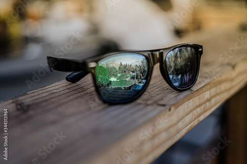 sunglasses on a wooden table © Diego