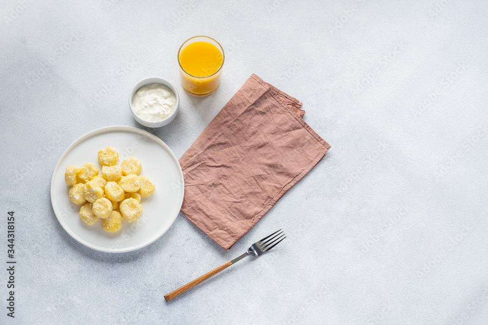 Curd and cheese dumplings served with berries and sour cream on a ceramic white plate. Traditional Ukrainian or Russian lazy dumplings (vareniki). Healthy Breakfast, top view. Curd and cheese dumplings served with berries and sour cream on a ceramic white plate. Traditional Ukrainian or Russian lazy dumplings (vareniki). Healthy Breakfast, top view.