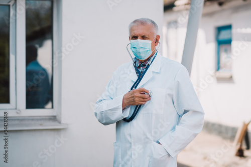 Senior doctor wearing surgical mask to prevent Coronavirus photo
