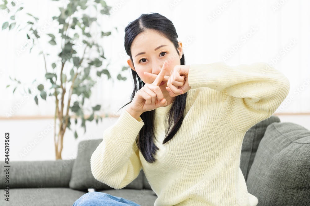 NGのサインを作る女性