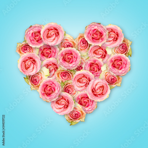 Bouquet of tea roses in the shape of a heart on a blue background. Valentine s Day.