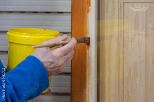 Una persona barnizando una ventana de madera photo