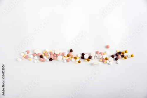 pills are on a white background, medicines of different colors are located along the length of the frame