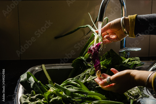 Manos lavando hojas verdes para alimento photo