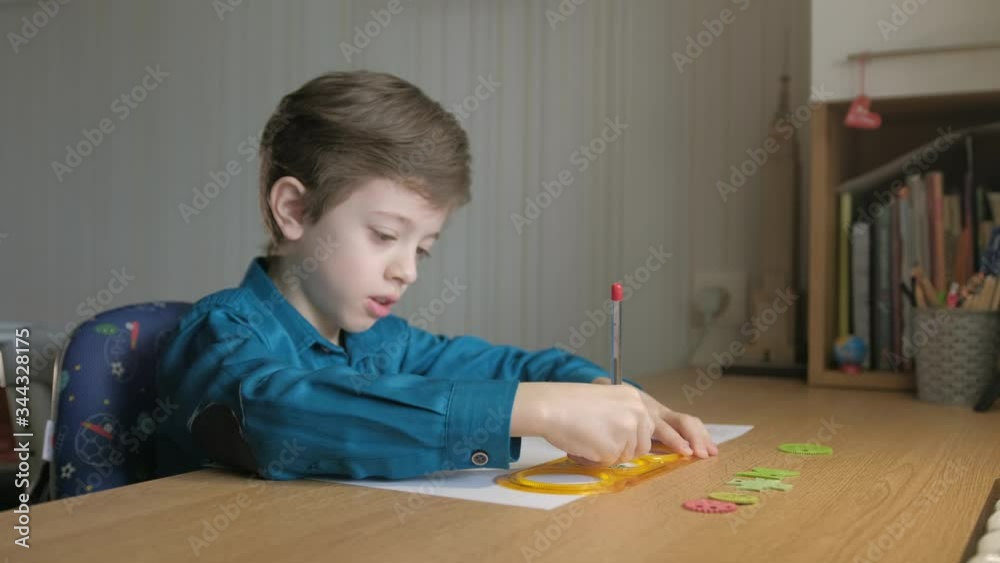Teenager draws with red pen patterns, using the graphical ruler Teenager draws with red pen patterns, using the graphical ruler