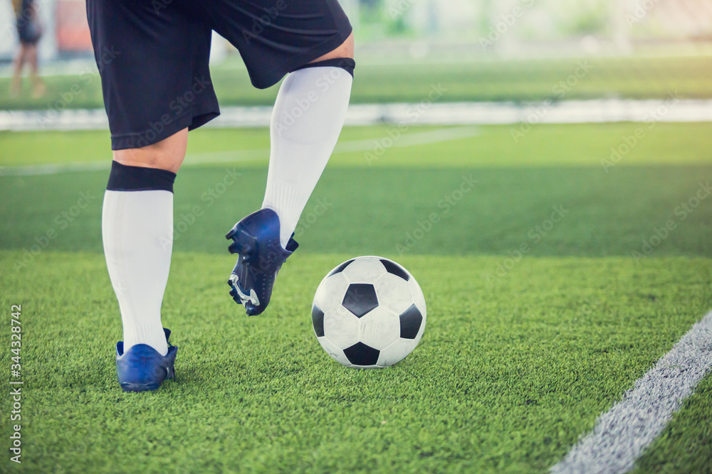 Soccer player control to shoot ball on green artificial turf to goal. Boy soccer player training for match. Football player in football academy.