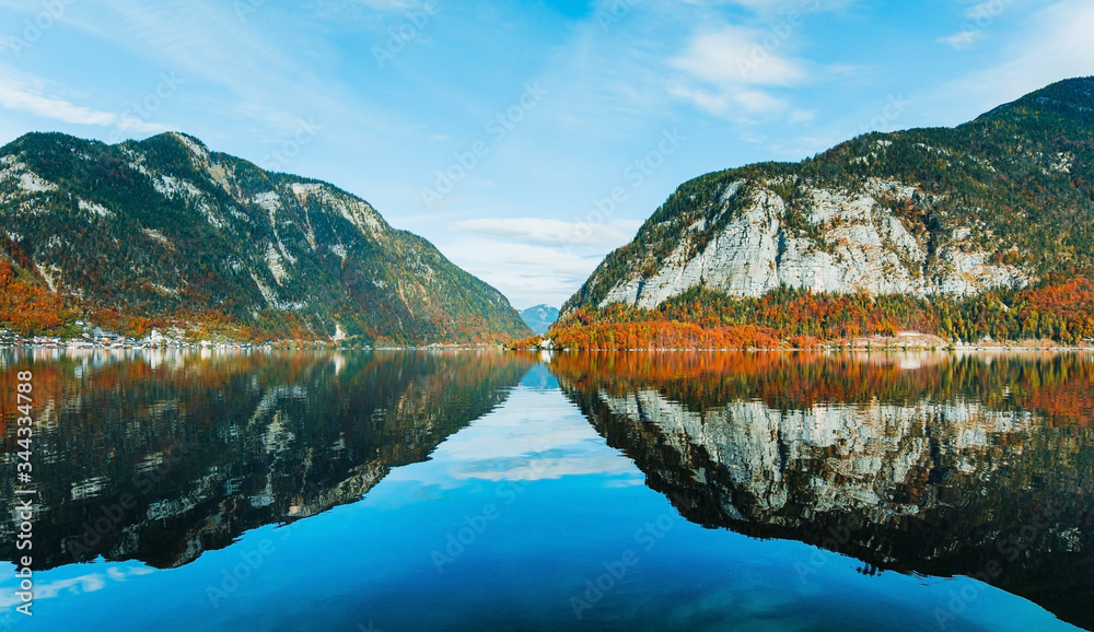 Panoramic view of the mountain village in the Austrian Alps. Autumn Landscape. Hallstatt, Austria. Blue sky and mountains. Beautiful and cozy town.Postcard concept. Hallstatter lake with reflections.