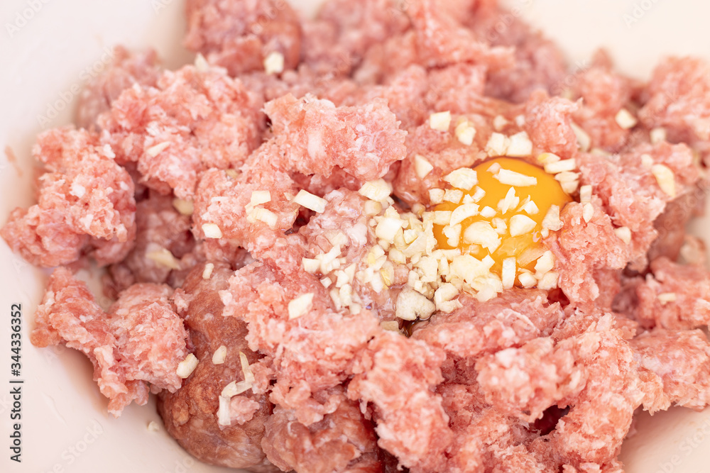 Raw minced meat with smashed eggs and chopped onion mixture for meatballs