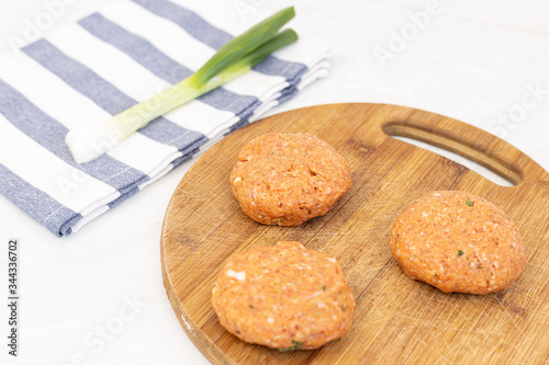 Raw minced meat meatballs on the wooden board ready for frying