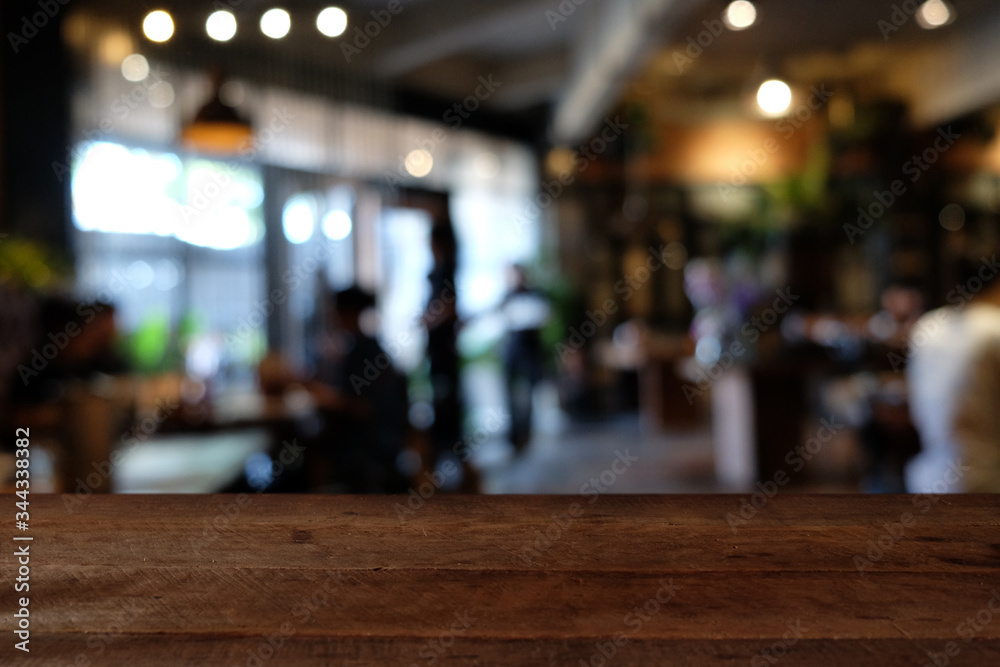 wood table on blur of cafe, coffee shop, bar, resturant, background - can used for display or montage your products