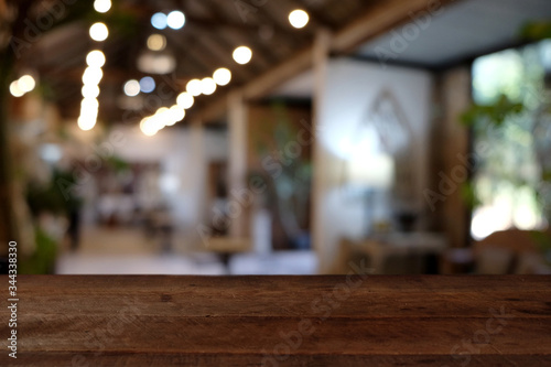 wood table on blur of cafe, coffee shop, bar, resturant, background - can used for display or montage your products
