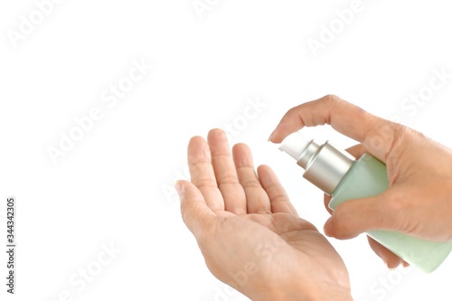 Woman's hand is pressing the green lotion bottle to take care of the beautiful skin