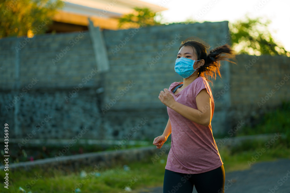 Asian woman in anti pollution face mask running workout - young dedicated  Korean girl jogging at beautiful city park on sunset enjoying fitness in  covid-19 pandemic times foto de Stock | Adobe Stock