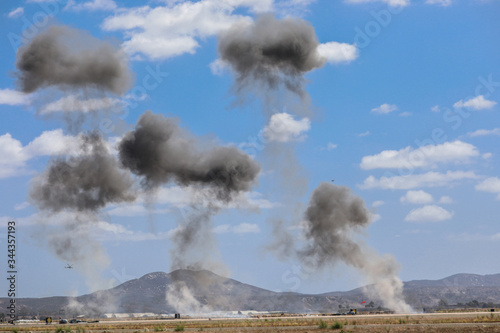 Giant outdoors explosion with fire and black smoke with mountain on the background