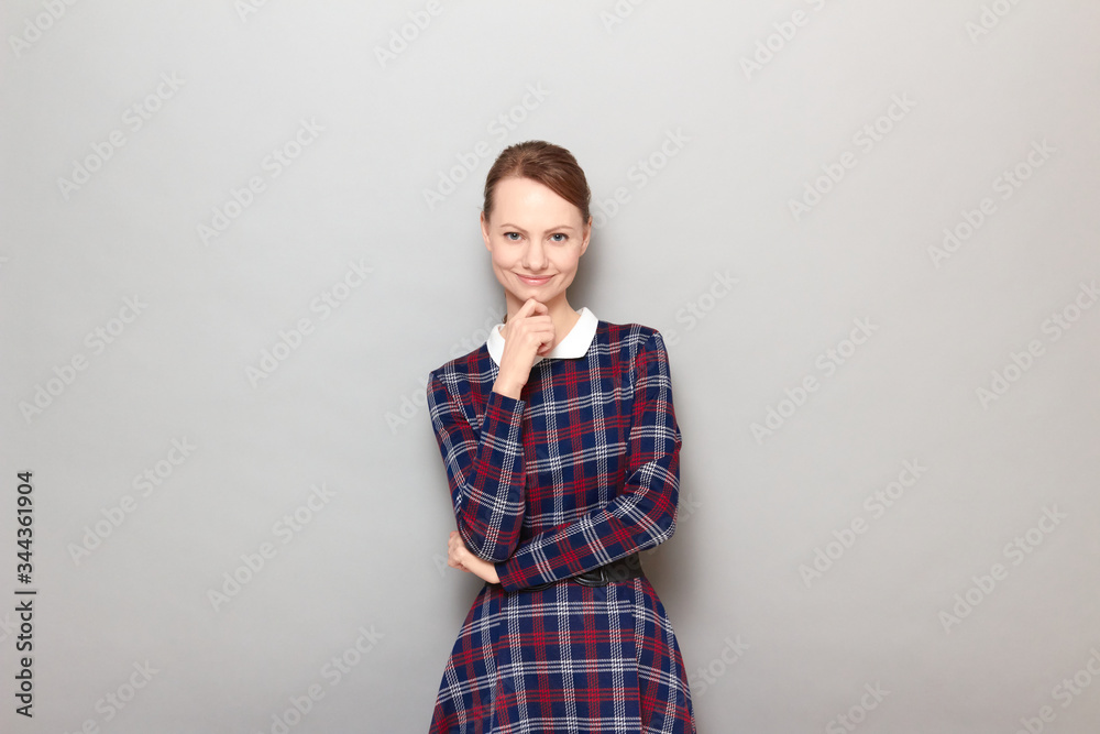 Portrait of happy young woman touching chin with hand and smiling