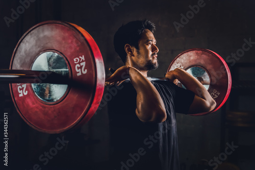Quadro su tela asian athletic strong man having workout and bodybuilding with barbells weightli