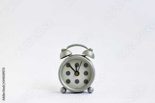gray alarm clock with polka dots on white background