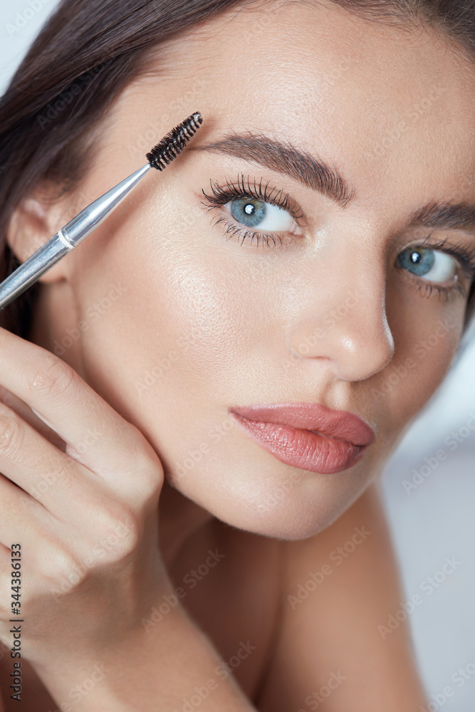 Eyebrow Makeup. Woman Brushing Brows With Brush. Beautiful Girl With Blue Eyes And Perfect Skin Close Up Portrait.