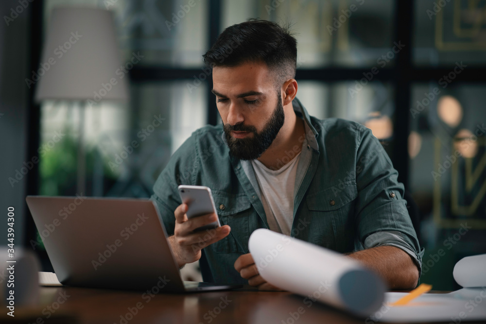 Young businessman using the phone in office. Handsome man at work. Young businessman using the phone in office. Handsome man at work.