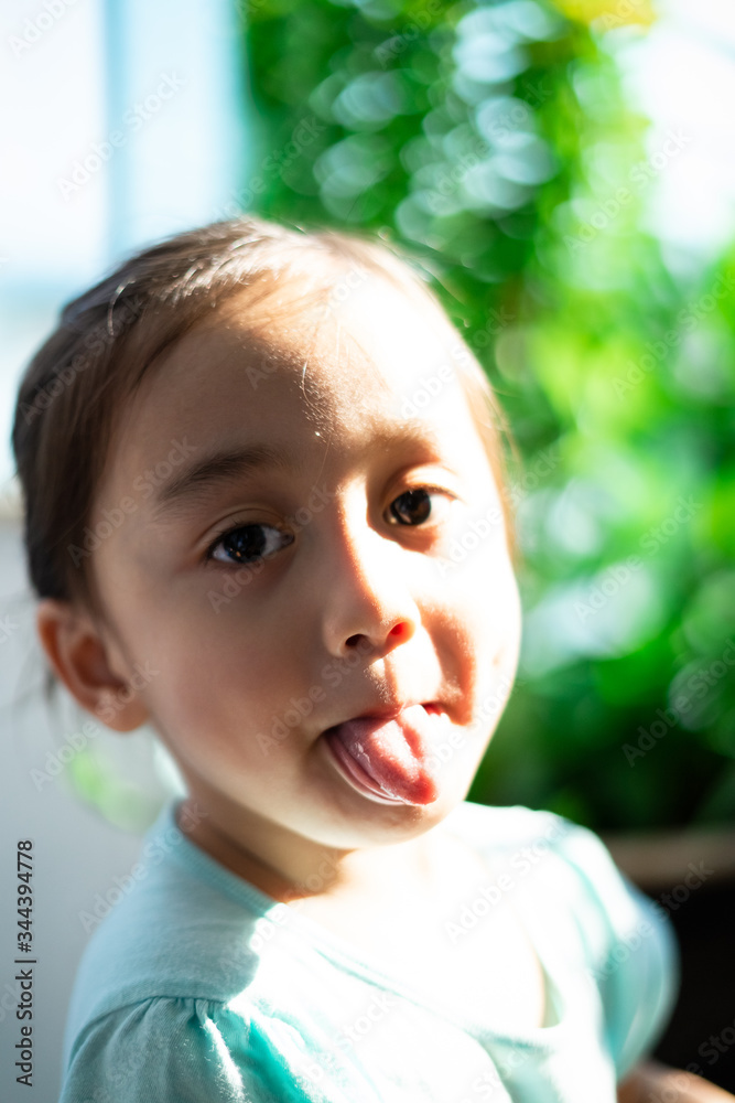 Outdoor portrait of an Asian little kid under the sunlight on her face. Outdoor portrait of an Asian little kid under the sunlight on her face.