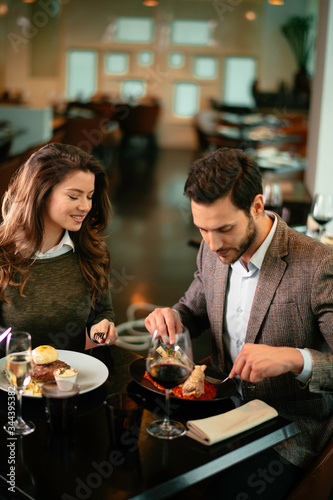 Happy loving couple enjoying in restaurant. Young couple enjoying in food. 