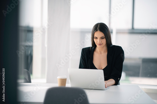 Young businesswoman working on lap top. Beautiful woman in office. 