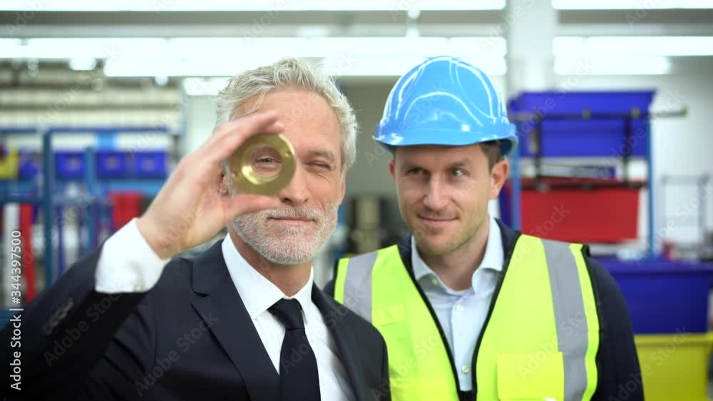 Manager and skilled worker checking metal part in factory