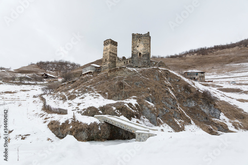 Old stone house and tower in cold winter in Caucasus Mountains. Mestia, Svaneti, Georgia,  Caucasus, Europe photo