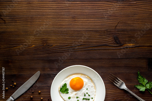 Fried eggs on plate on wooden table top view copy space