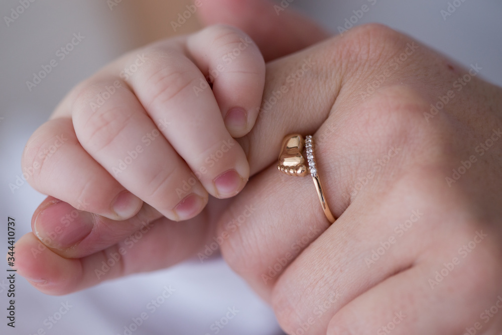 A child's hand on a mother's finger