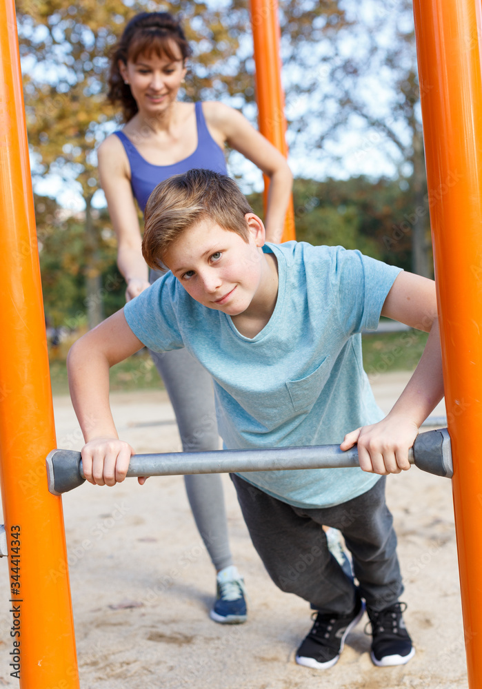Fototapeta premium Boy doing push-ups with mother