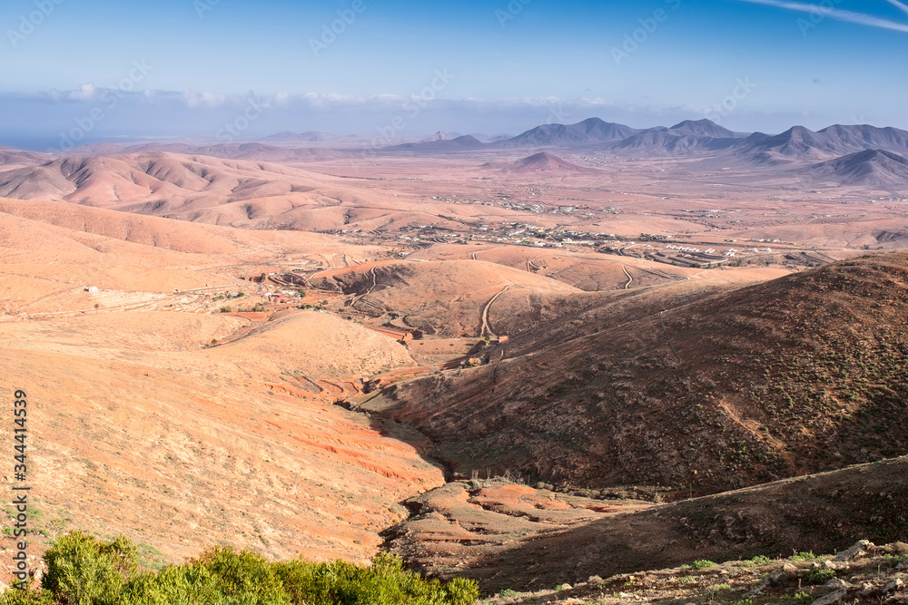 Volcanic mountains panorama with rocky desert terrain , blue cloudy sky, Fuerteventura, Canary Islands, Spain .