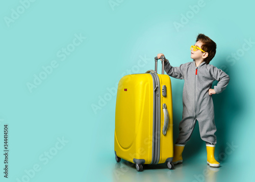 Quadro em tela Self-confident kid boy in gray overall, yellow rubber boots and sunglasses stand