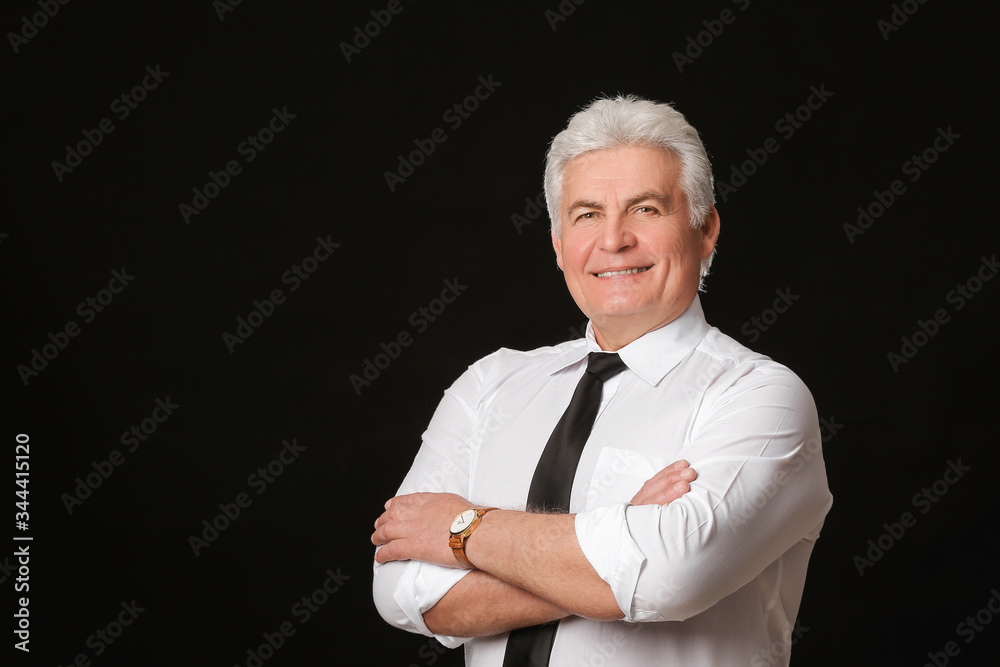 Portrait of handsome senior businessman on dark background
