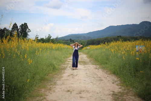 A woman standing in the crotalaria juncea field in Rayong, Thailand © pantkmutt