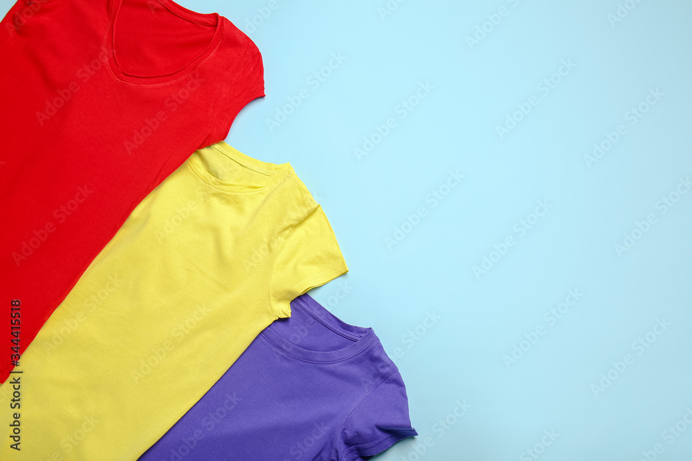Stylish t-shirts on color background