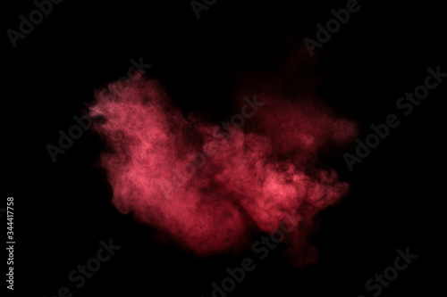 Red and pink powder explosion on black background. Colored powder cloud. Colorful dust explode. Paint Holi.