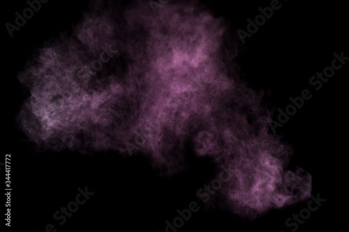 Purple powder explosion on black background. Colored powder cloud. Colorful dust explode. Paint Holi.