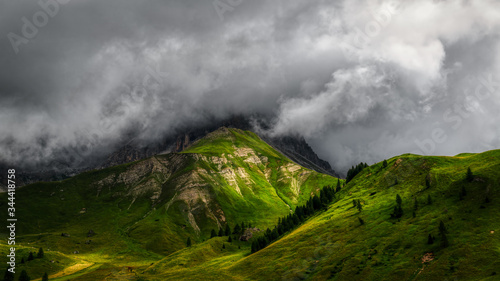 Sunlight over the mountains with storm clouds in the sky, Dolomites photo