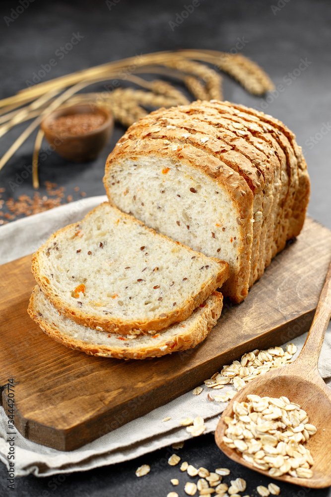 Bread on a wooden background, eggs, flour in a bowl, rye, bread knife, cereals