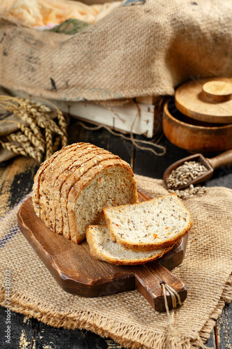 Bread on a wooden background, eggs, flour in a bowl, rye, bread knife, cereals