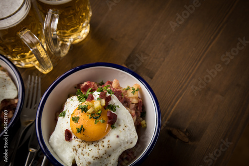 Norddeutscher Hamburger Labskaus mit Rindfleisch Corned Beef, Rote Beete, Kartoffeln, Saure Gurken, Spiegelei, Rollmops und Bier auf Holztisch photo