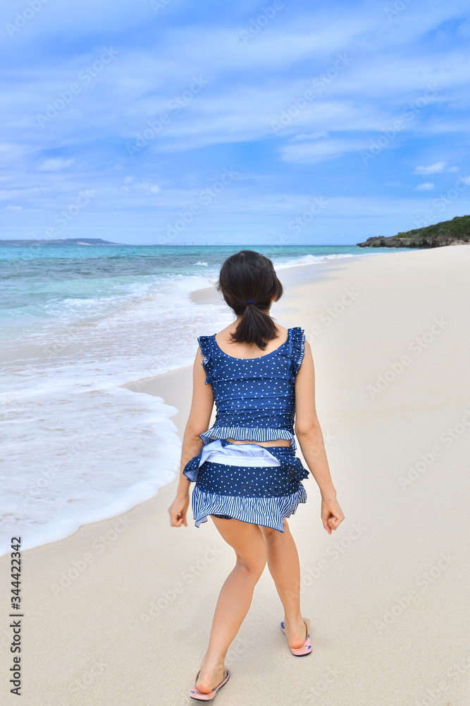 ビーチでジャンプする女の子(沖縄　宮古島　長間浜　後姿)